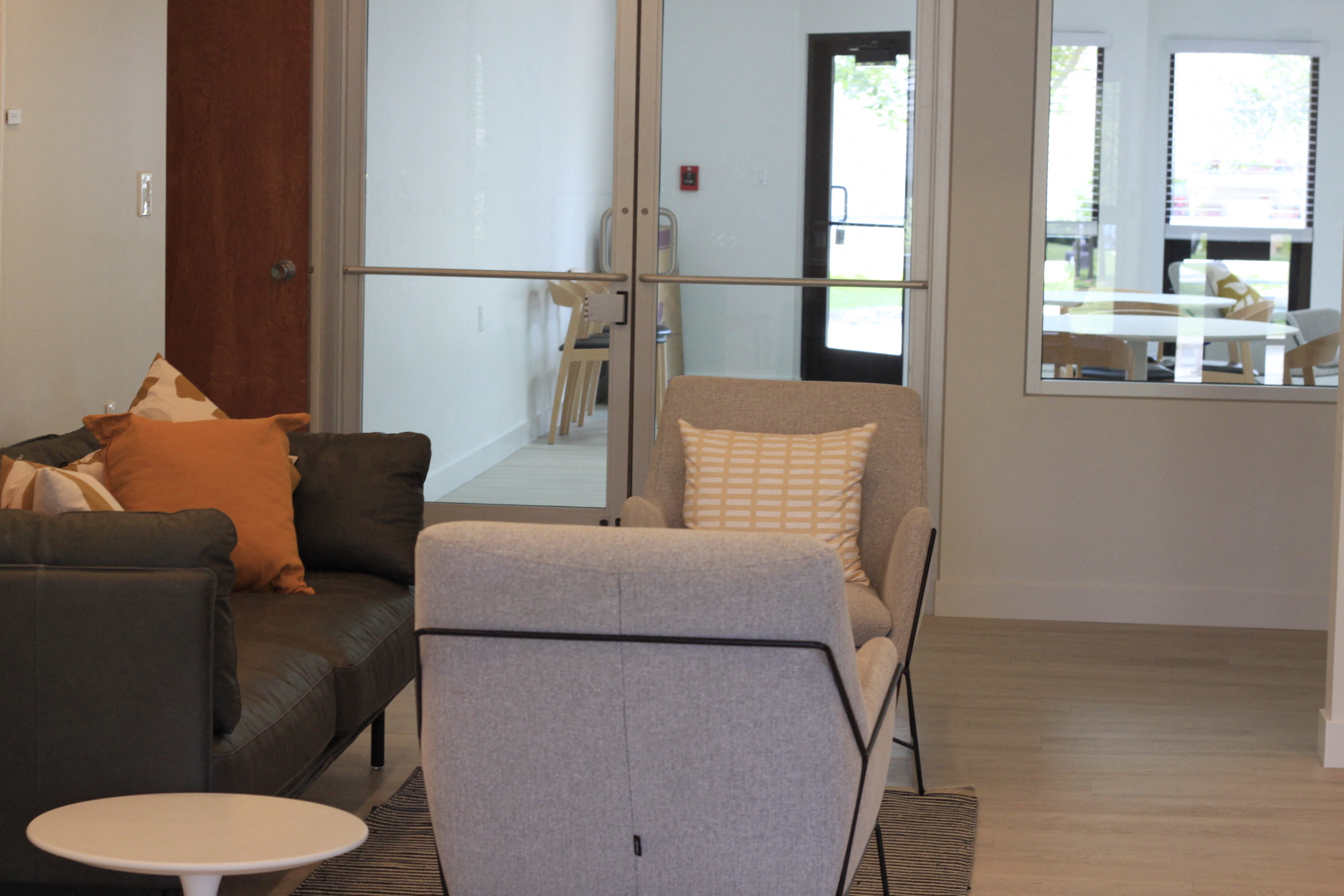 a living room with a couch and a chair and a glass door